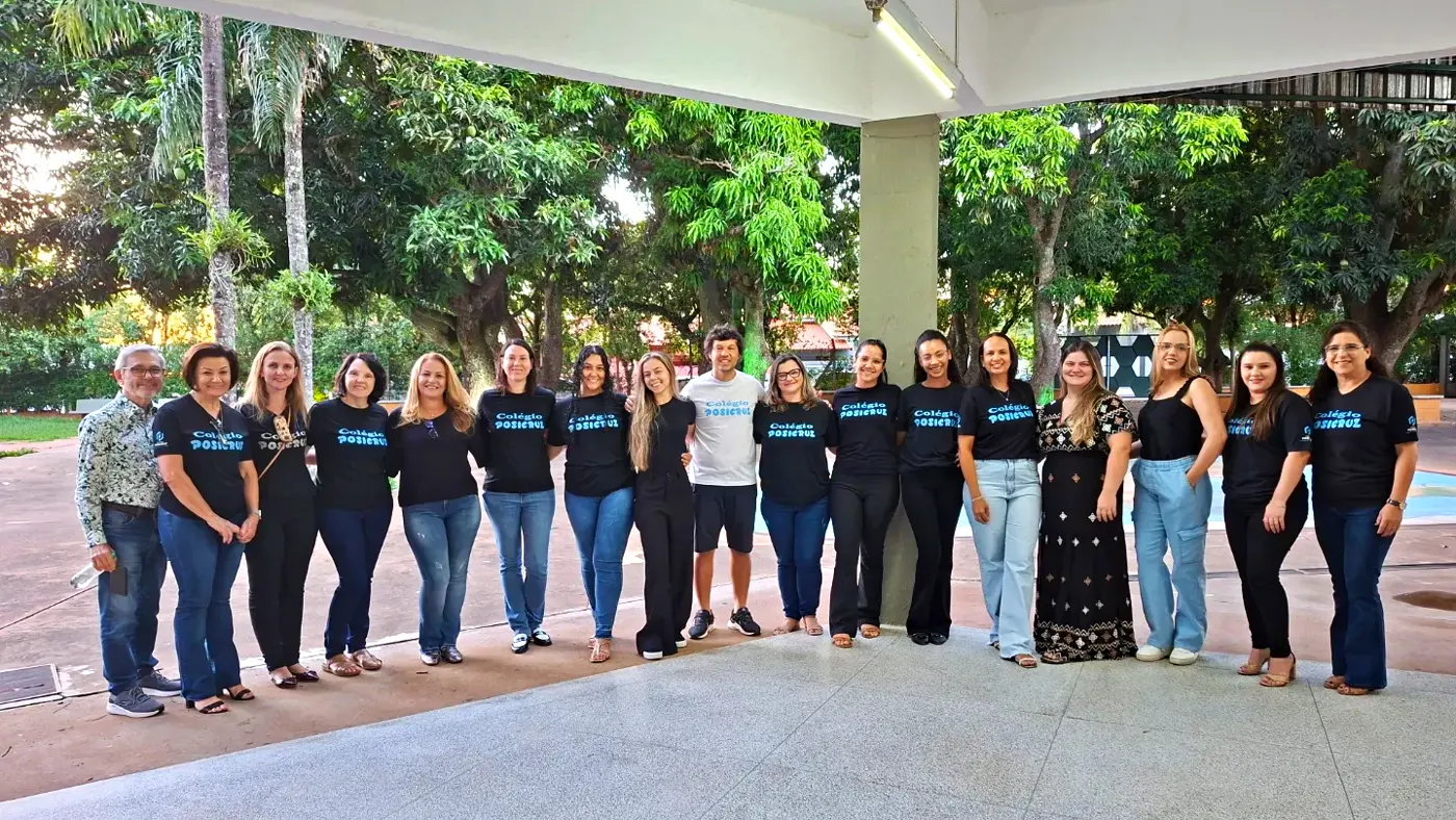 Equipe de professores e colaboradores do Colégio Posicruz reunida no pátio da escola